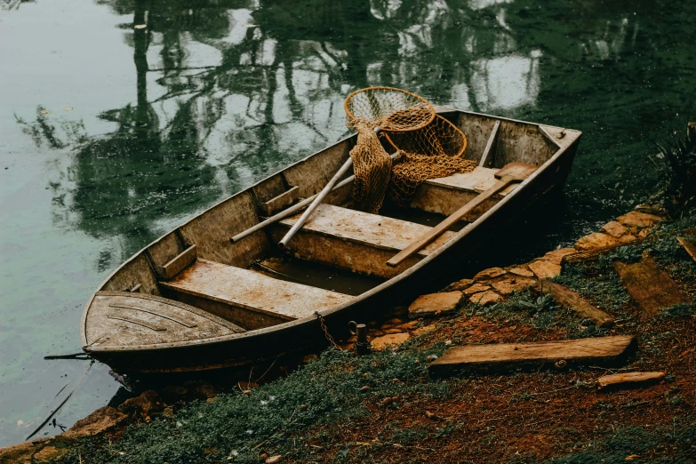a boat with a wooden deck sitting in a small pond