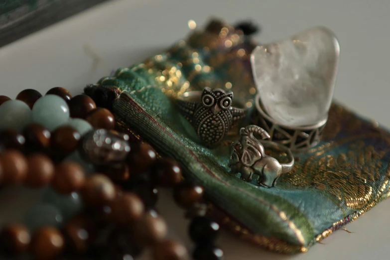 an assortment of beads and accessories with an owl figurine