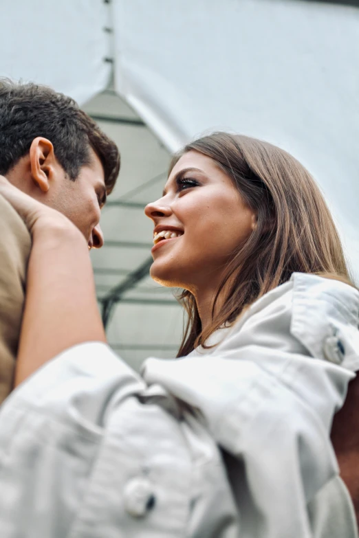 a beautiful woman holding a man behind her