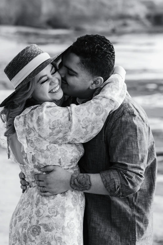 a couple kissing by the ocean at low tide