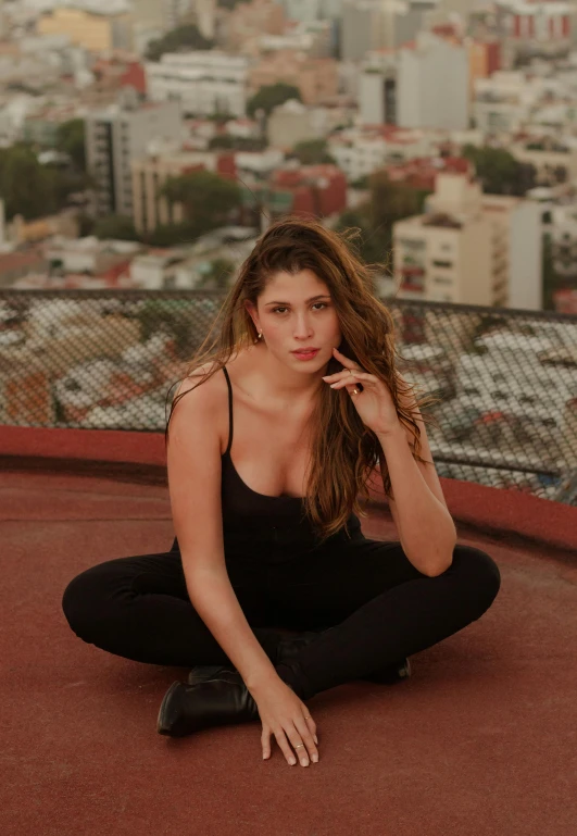 a young lady posing in black clothes near the city