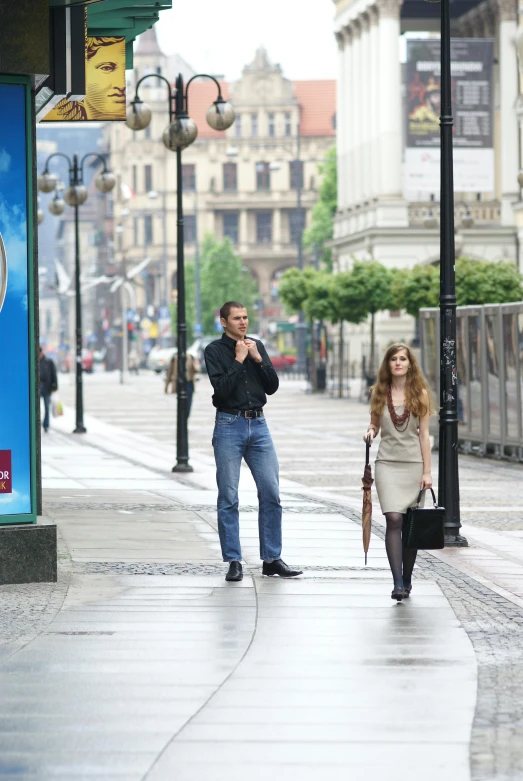 a man and woman standing on a city sidewalk