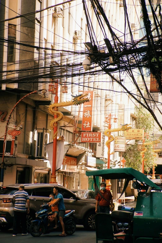 two men hing carts down the road near some cars