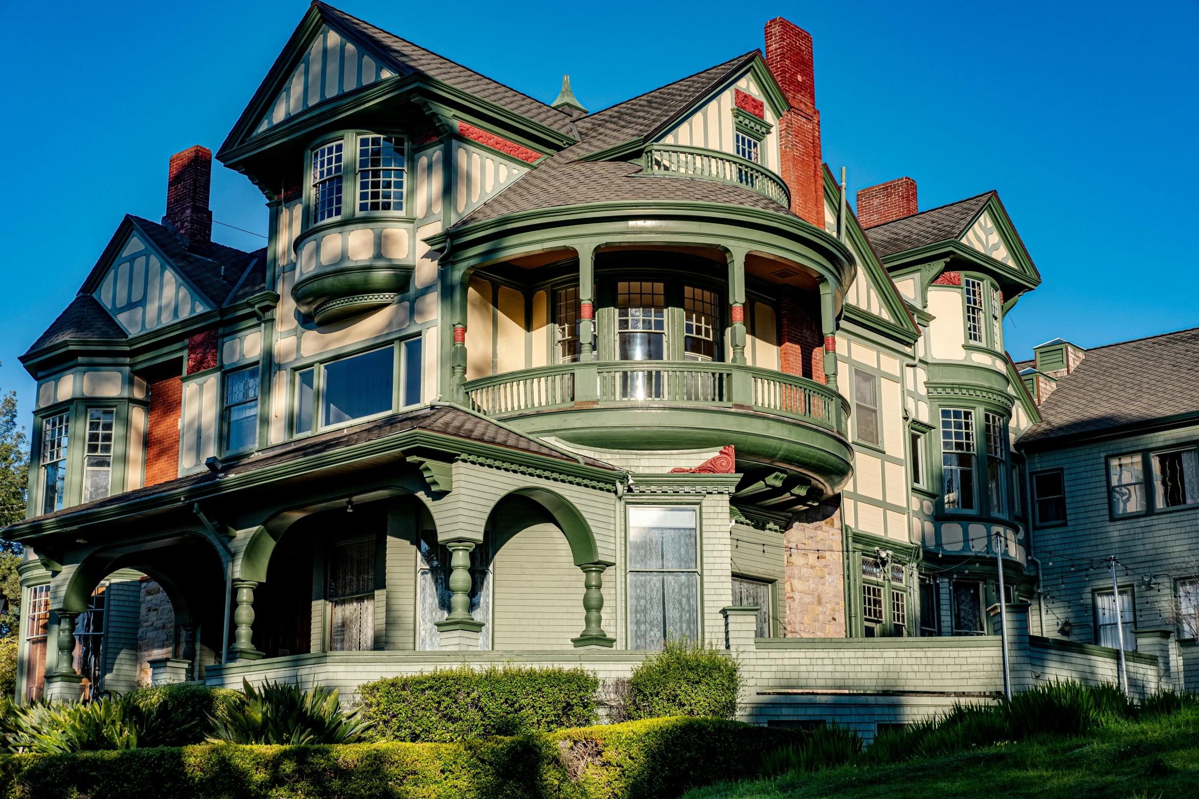 a large gray house that has red and brown trim