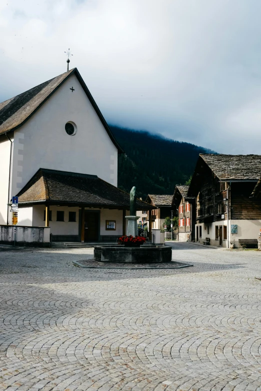 a white church stands near a cobblestone courtyard