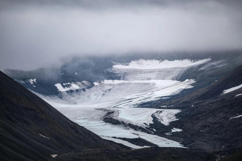 the view from atop of a mountain top that has snow and ice flowing down the valleys