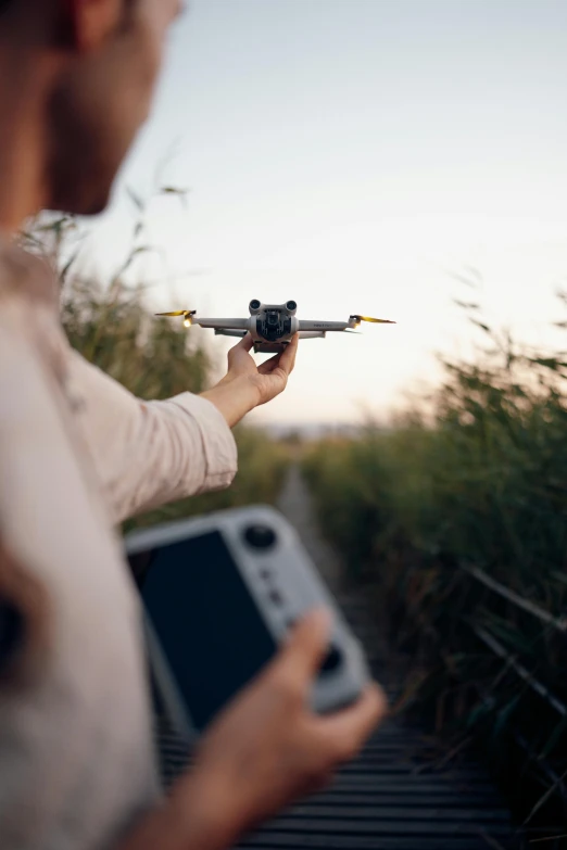 a person holding a cell phone and an object with wings in the air