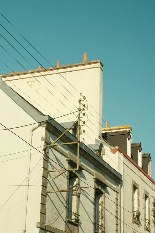 a white building with a clock tower and various electrical wires