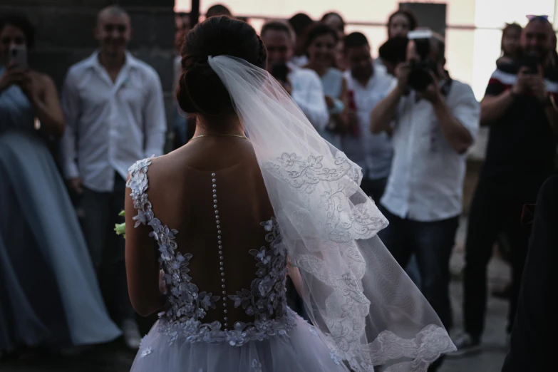 the back view of a bride's dress with long veil