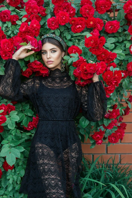 a woman posing in front of flowers with her arms over her head