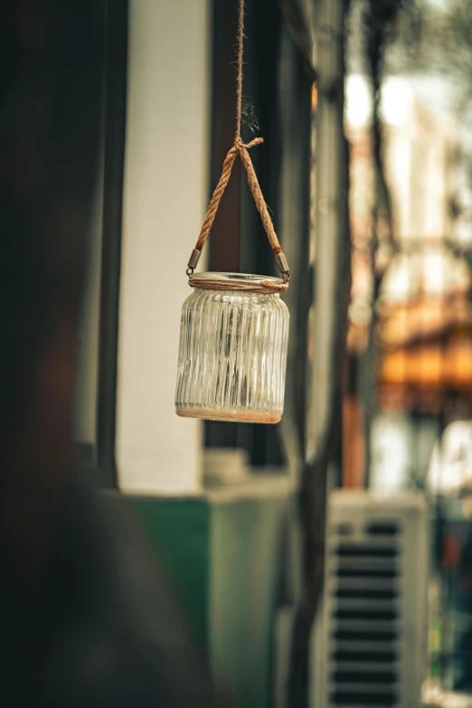 a hanging glass jar filled with water on a street