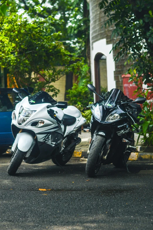 two motorcycles parked on the side of the road near trees