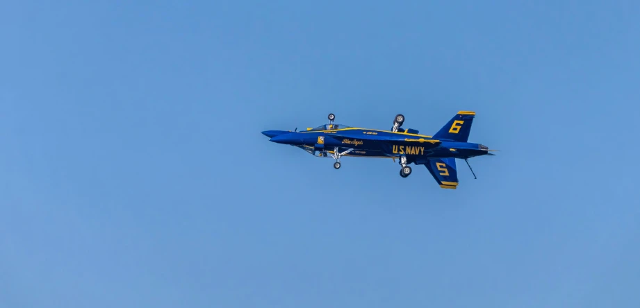 a blue and yellow military plane flying through the air