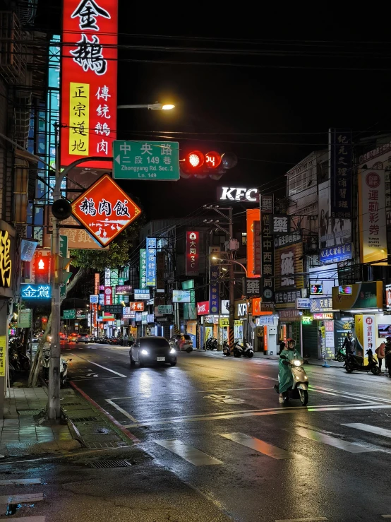 a wet street with cars and signs on it