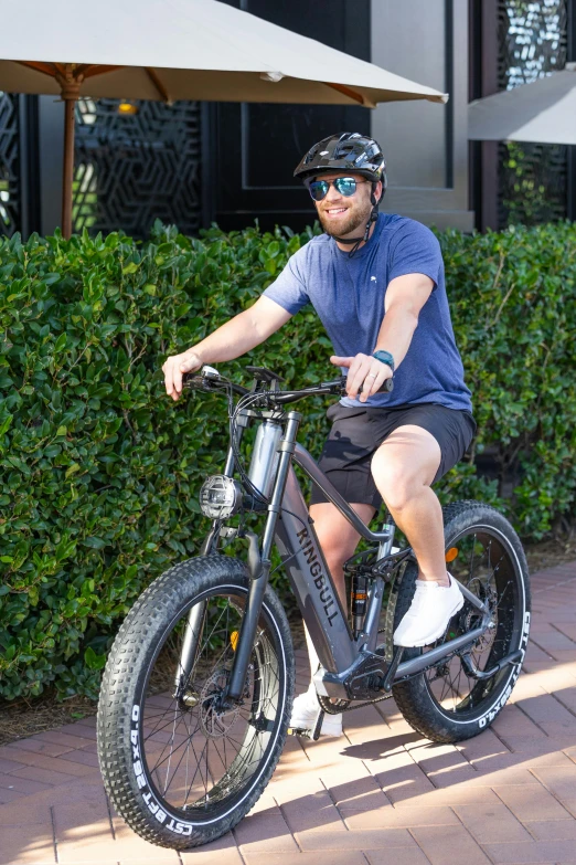 a man riding a bicycle down a sidewalk