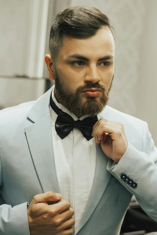 man adjusts his bow tie in the mirror