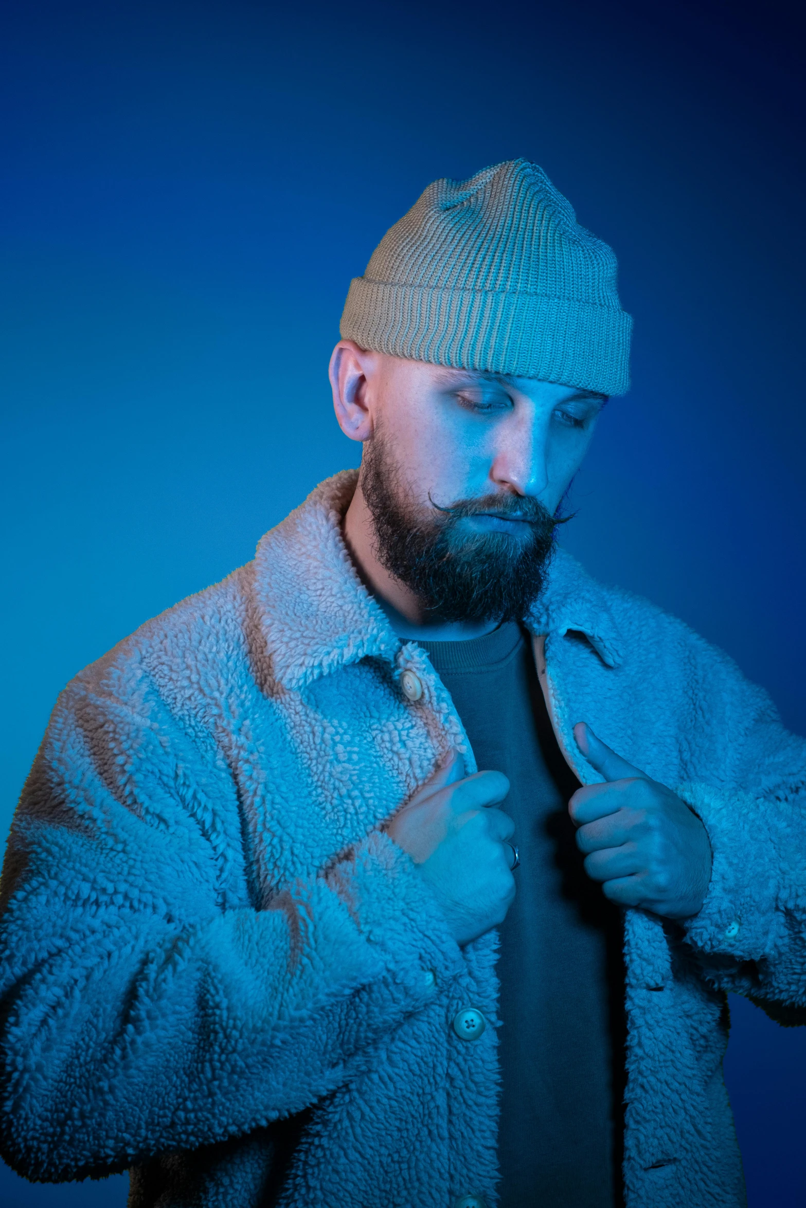 a bearded man posing for a portrait in the dark