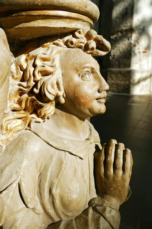 a close - up of a statue of a man's face with hair flowing down