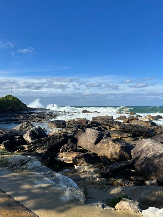 rocks and a lighthouse sitting on top of the ocean