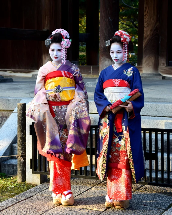 two geisha girls are holding their costumes