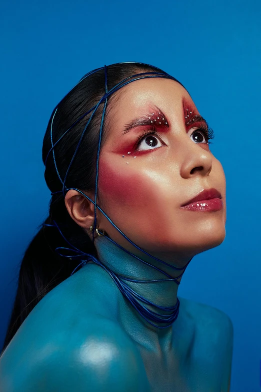 a woman with black hair and red and silver makeup