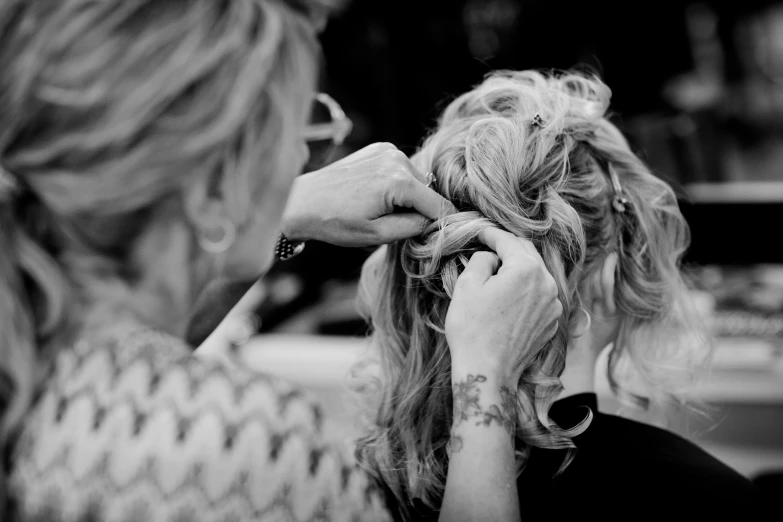 a woman blow drying a girl's hair in the sun