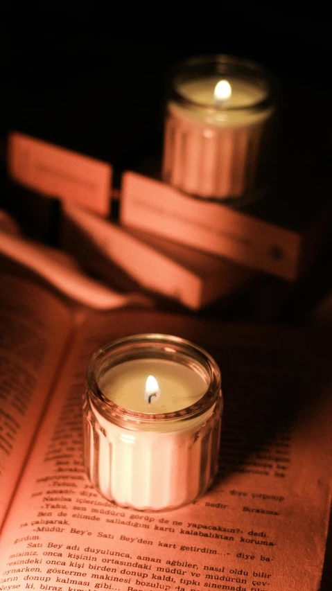 a candle sitting on top of a book with light coming through it