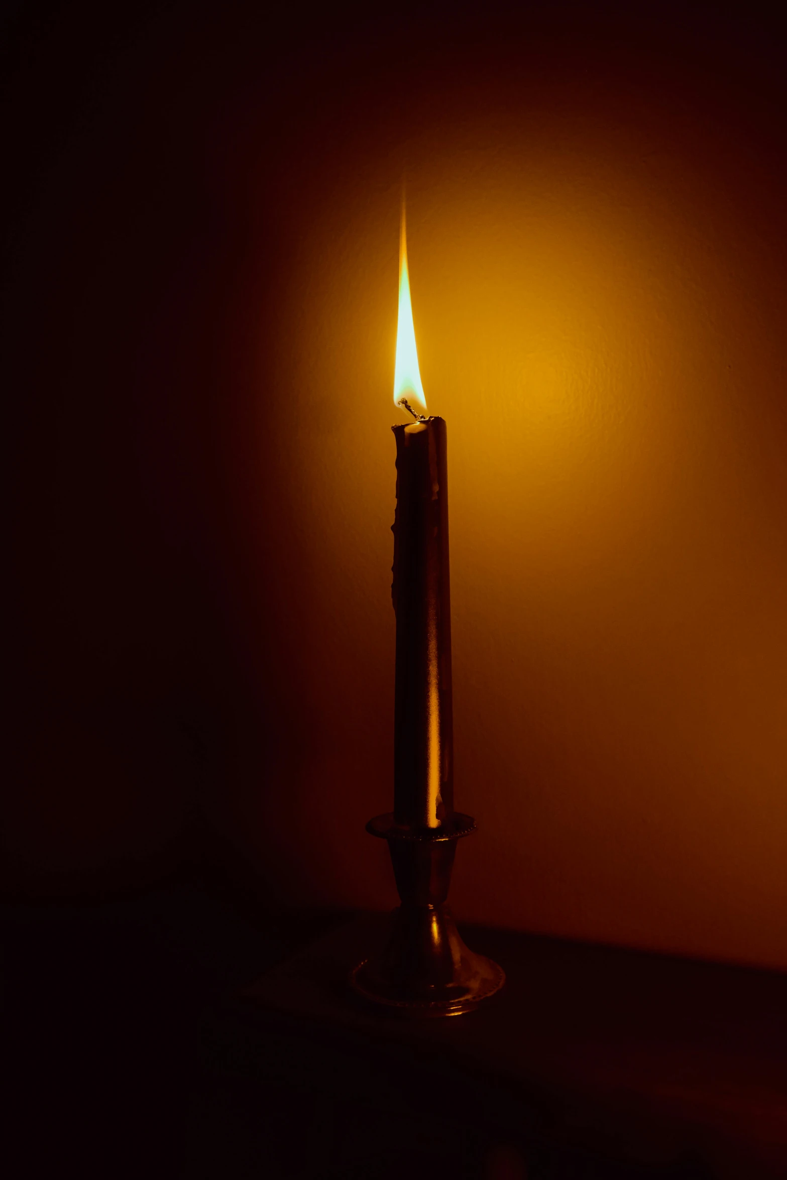 a candle burning in a dark room during the day