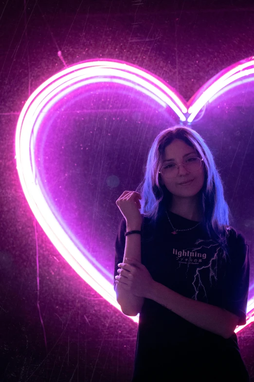 a woman holding an electric guitar near a giant heart