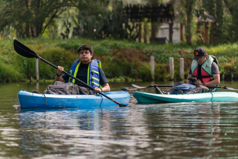 two people in kayaks paddle in a river