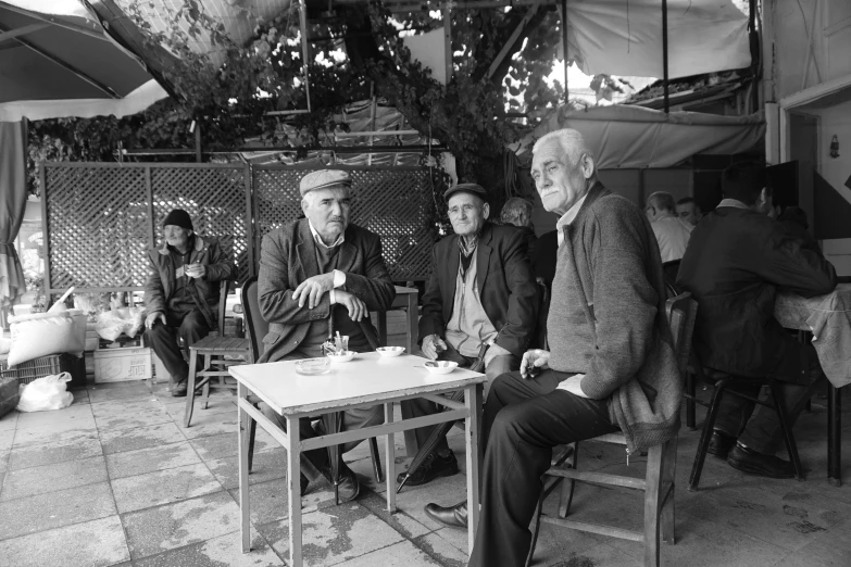 black and white pograph of four men sitting outside