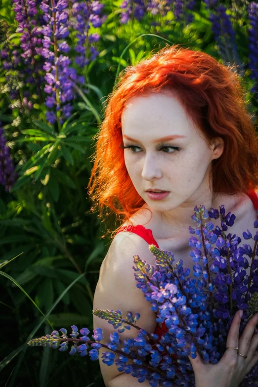 a beautiful young lady holding a bouquet of wild flowers