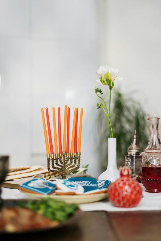 a white table topped with a glass vase filled with flowers and candles