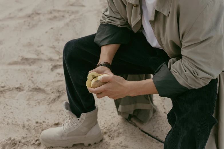 a man is eating a  dog on the beach