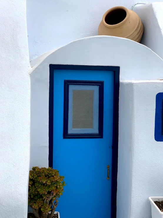 a blue and white building with a potted plant