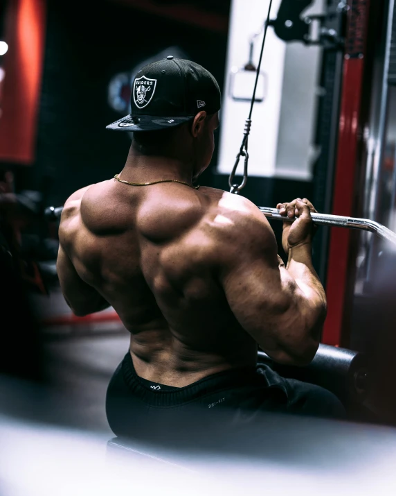 a man with  on, in the gym holding a bar