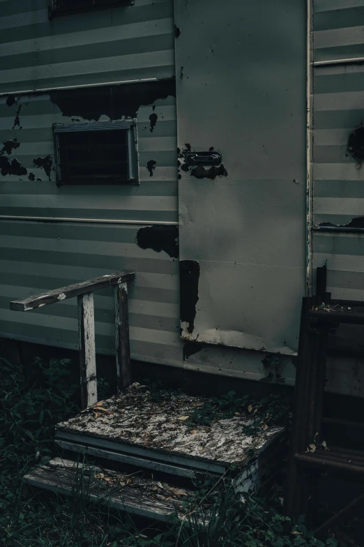 a run down building with crumbling windows and some trash cans