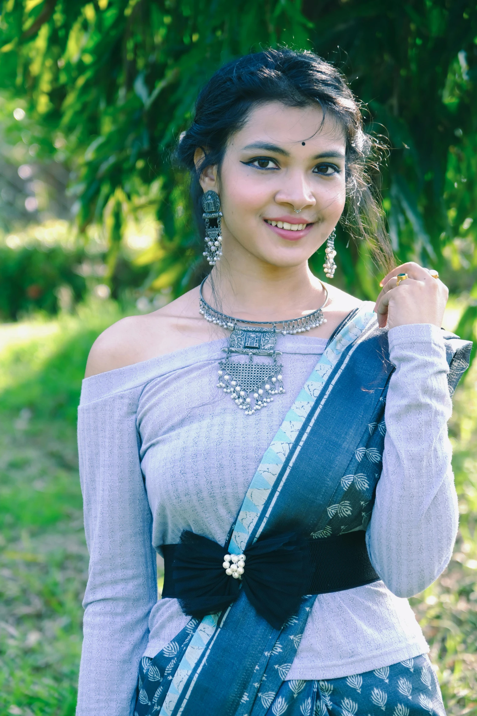 a woman with dark hair and a gray dress is smiling at the camera