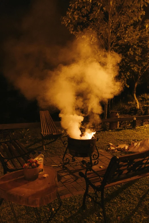 a fire and smokestack is glowing in the night