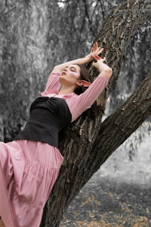 a beautiful woman lying down on a tree