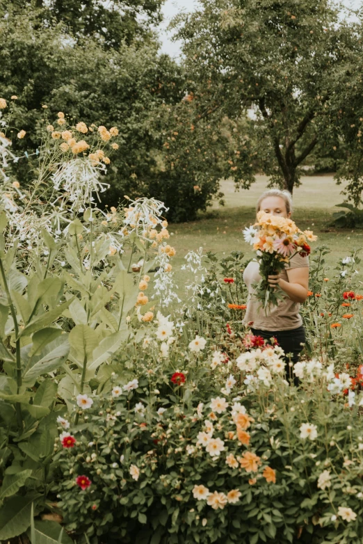 a little girl standing in front of some flowers