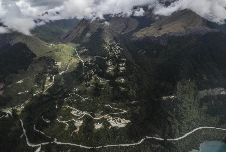 an aerial po of a small village nestled on a green mountain