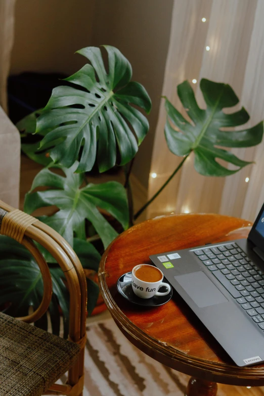 a table with a laptop and coffee cup sitting on it