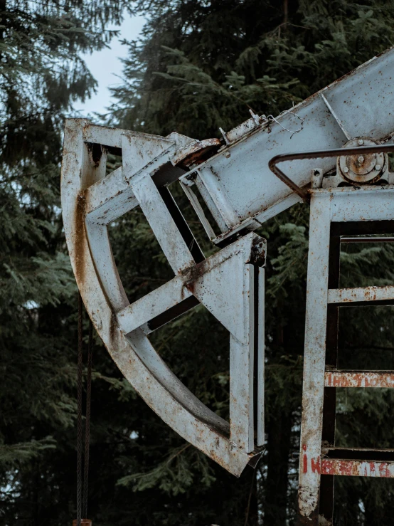 an old and rusty truck has a tree in the back ground