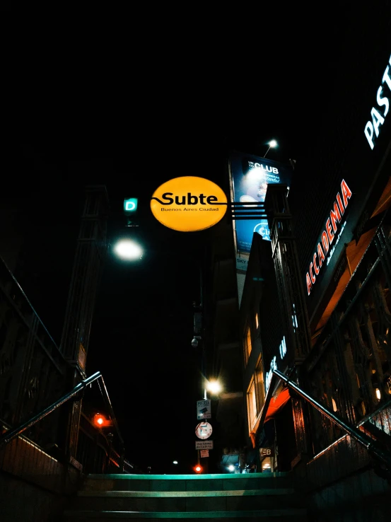 the neon sign is above the dark street