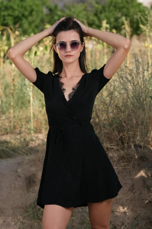 a woman in sunglasses is posing outside