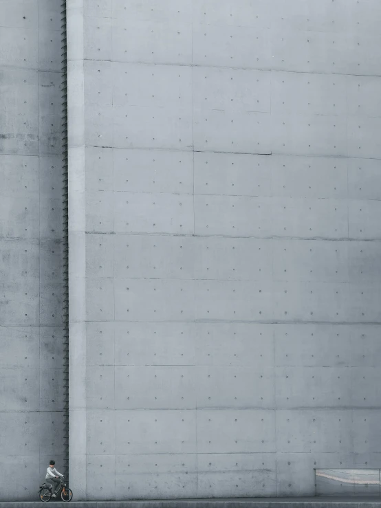 person in white jacket and hat riding a bike near building