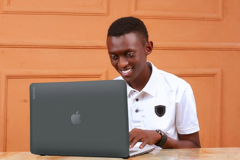 smiling young man using the macbook air keyboard