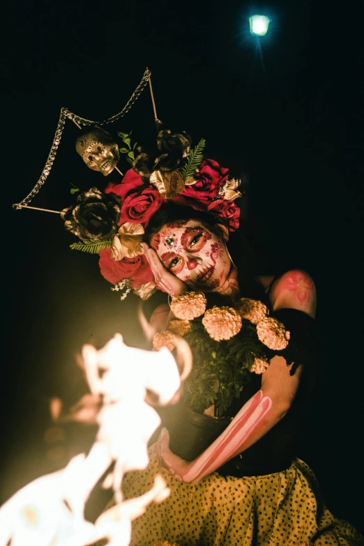 a woman with makeup on and red flowers on her head