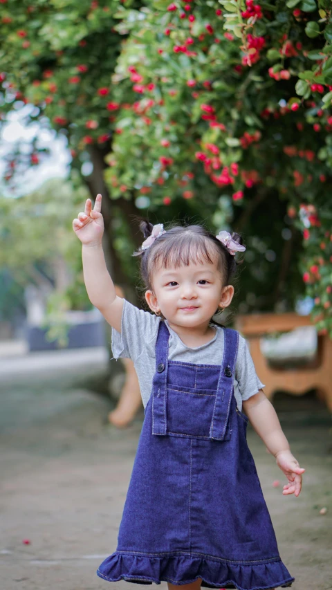 a small child holding her hand in the air